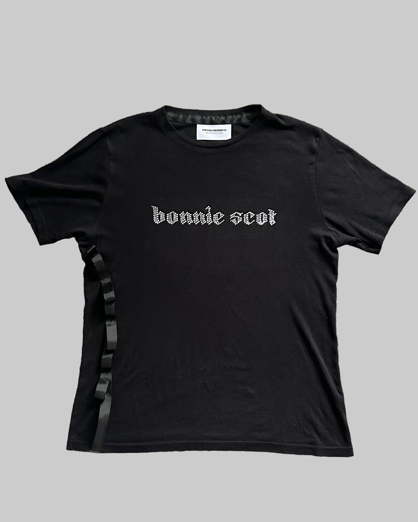 Black t-shirt with 'bonnie scot' text on a gray textured background